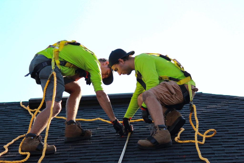Two roofers are making roof installation services
